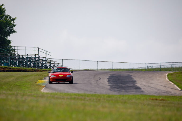 a red car driving on the VIR track on a grey cloudy day